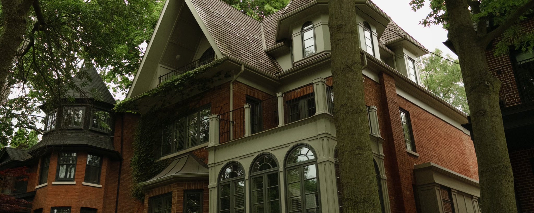 A Canadian brick home framed by mature trees