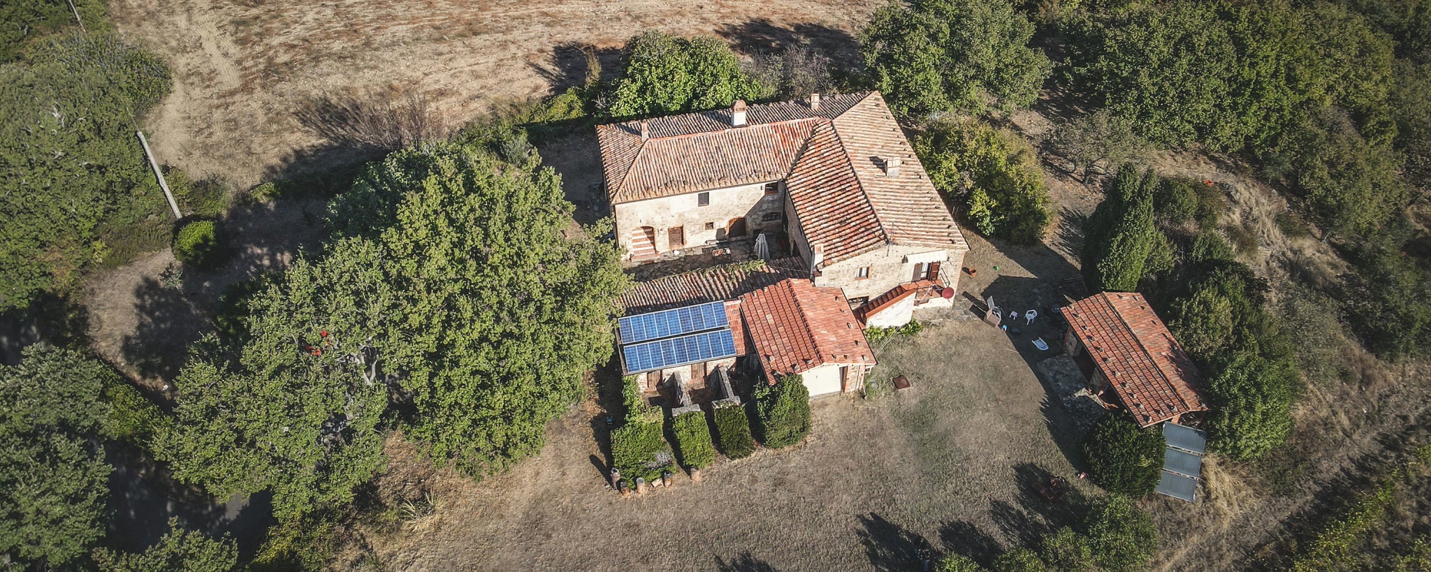 Aerial view of a rural house with rooftop solar panels, illustrating documented green-development features